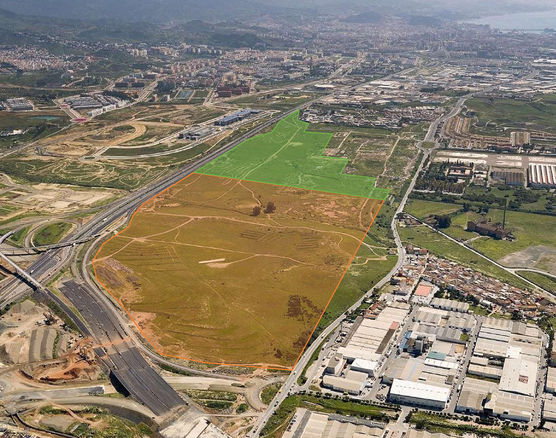 Foto aérea del Ámbito de Buenavista. Se ve una zona marcada en naranja que será industrial y otra en verde que será residencial. Al fondo se ve la ciudad de Málaga y el mar.